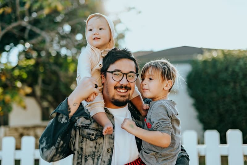 Father with children in front of a safe family neighbourhood