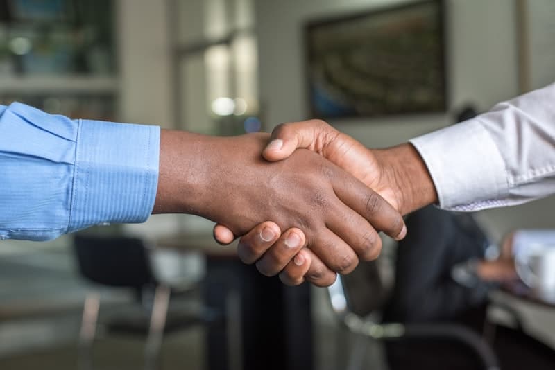 Neighbours shaking hands and building community trust